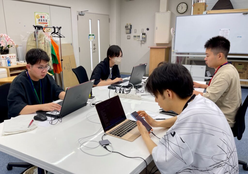 スマートフォンアプリ開発に集中する4名の学生さん達
